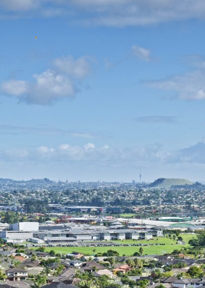 Aerial view of East Tamaki Heights suburban houses with hills on the horizon